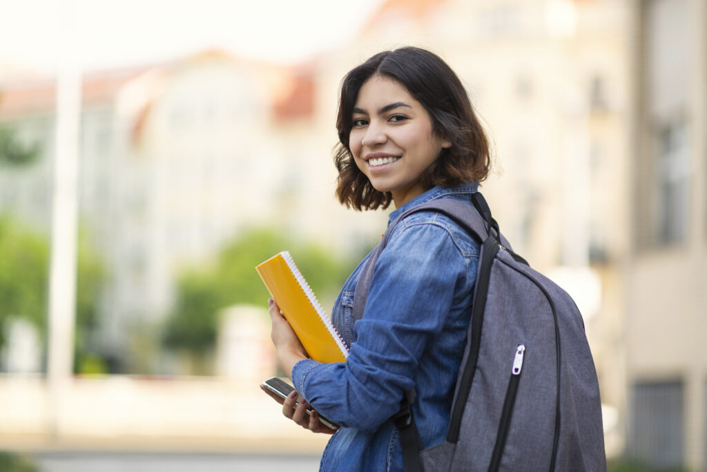 Smiling college student holding books. Photo for Industry Resources page