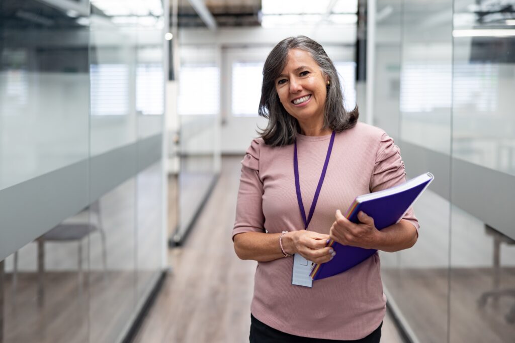 Professor standing in hallway holding notebook Educators Grants
