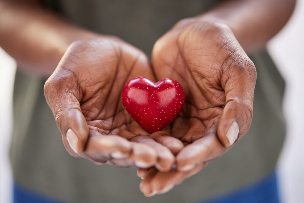 Brown hands holding heart. Photo for the Ways to Give